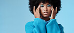 Blue makeup, fashion and beauty with a black woman in studio against a wall background for a photo shoot. Cosmetics, face and eye shadow with a young female posing for contemporary or edgy style
