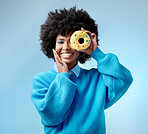 Black woman, smile and donut in hand with blue makeup against studio background. Model, happy and beauty with cake in face show happiness against fashion backdrop with hair, skin and healthy teeth