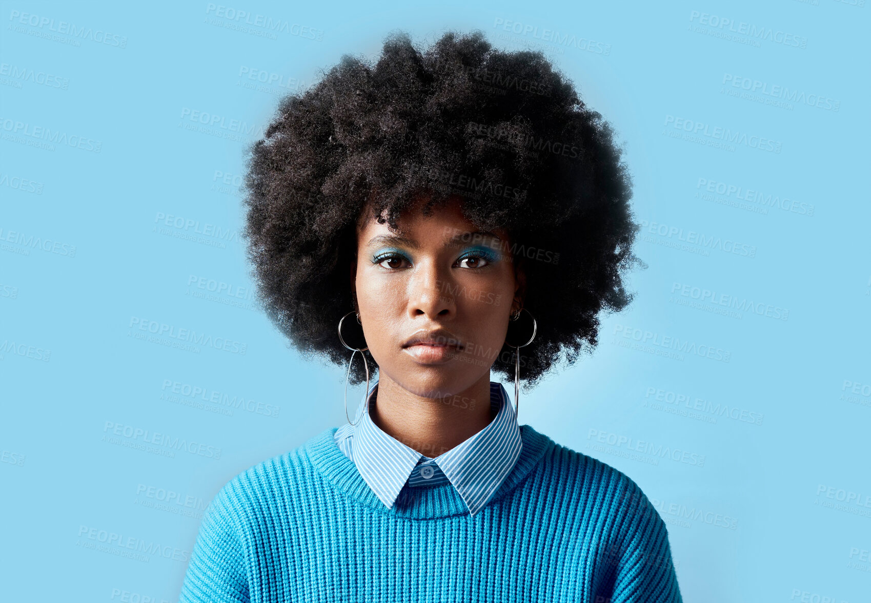 Buy stock photo Black woman afro, portrait and serious face for vision in focus against a blue studio background. African female model in cool fashion with cosmetic eyeshadow makeup on mockup