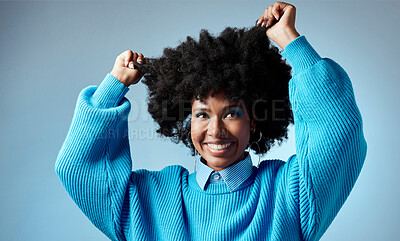 Buy stock photo Happy, black woman and healthy natural hair with afro against blue studio mockup background. Young beautiful female model looking trendy, beauty and empowerment with smooth glowing skin and fashion