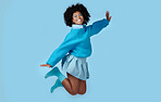 Fashion, jump and happy black woman in a studio with trendy, cool and stylish clothes with a blue background. Happiness, smile and portrait of a young african model with energy, excited and joy.