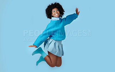 Buy stock photo Blue, jump and happy black woman in a studio with trendy, cool and stylish clothes with a background. Happiness, smile and portrait of a young african model with energy, excited and joy.