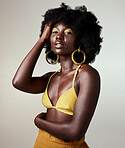 Black woman, beauty and fashion, makeup or hair care and gold jewelry on gray studio background. Portrait, hand in afro hair and skincare cosmetics model from Jamaica posing for female empowerment.