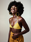 Beauty, black woman and portrait with afro and bikini fashion top showing glowing skin in studio. Happy, cheerful and edgy african girl with natural hair and trendy yellow makeup with mockup.

