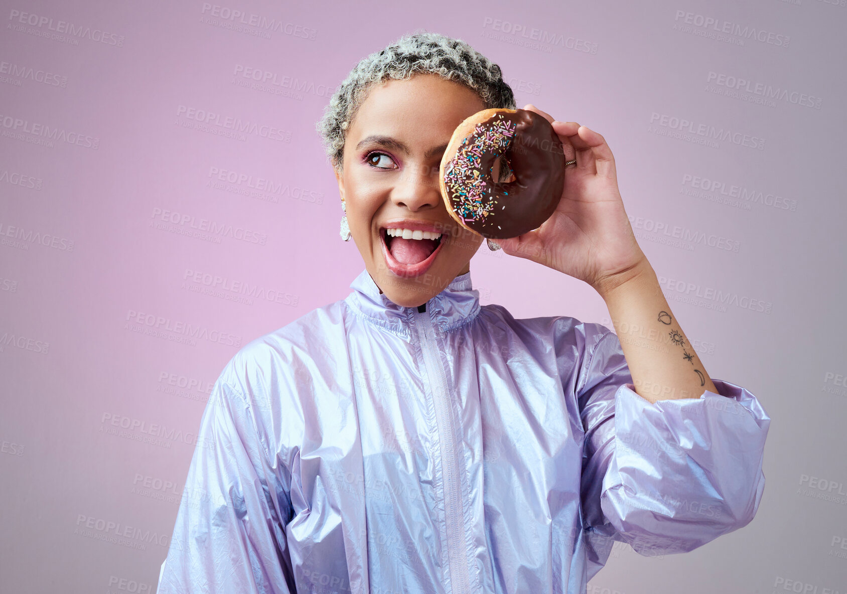 Buy stock photo Fashion, donut and black woman excited and happy about dessert with futuristic vaporwave or holographic style clothing against purple background. Face of a happy female model looking cool and trendy