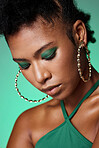 Beauty, fashion and makeup with a black woman in studio on green background with eye shadow and jewelry. Face, cosmetics and accessories with an attractive young female posing for empowerment
