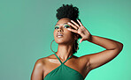 Beauty, fashion and empowerment with a beautiful black woman in studio of a green background for style. Makeup, cosmetics and trendy with an edgy female model posing for individuality and equality