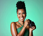 Photography, camera and portrait of a happy black woman standing in a studio with a green background. Happy, smile and professional young african creative female photographer from south africa. 