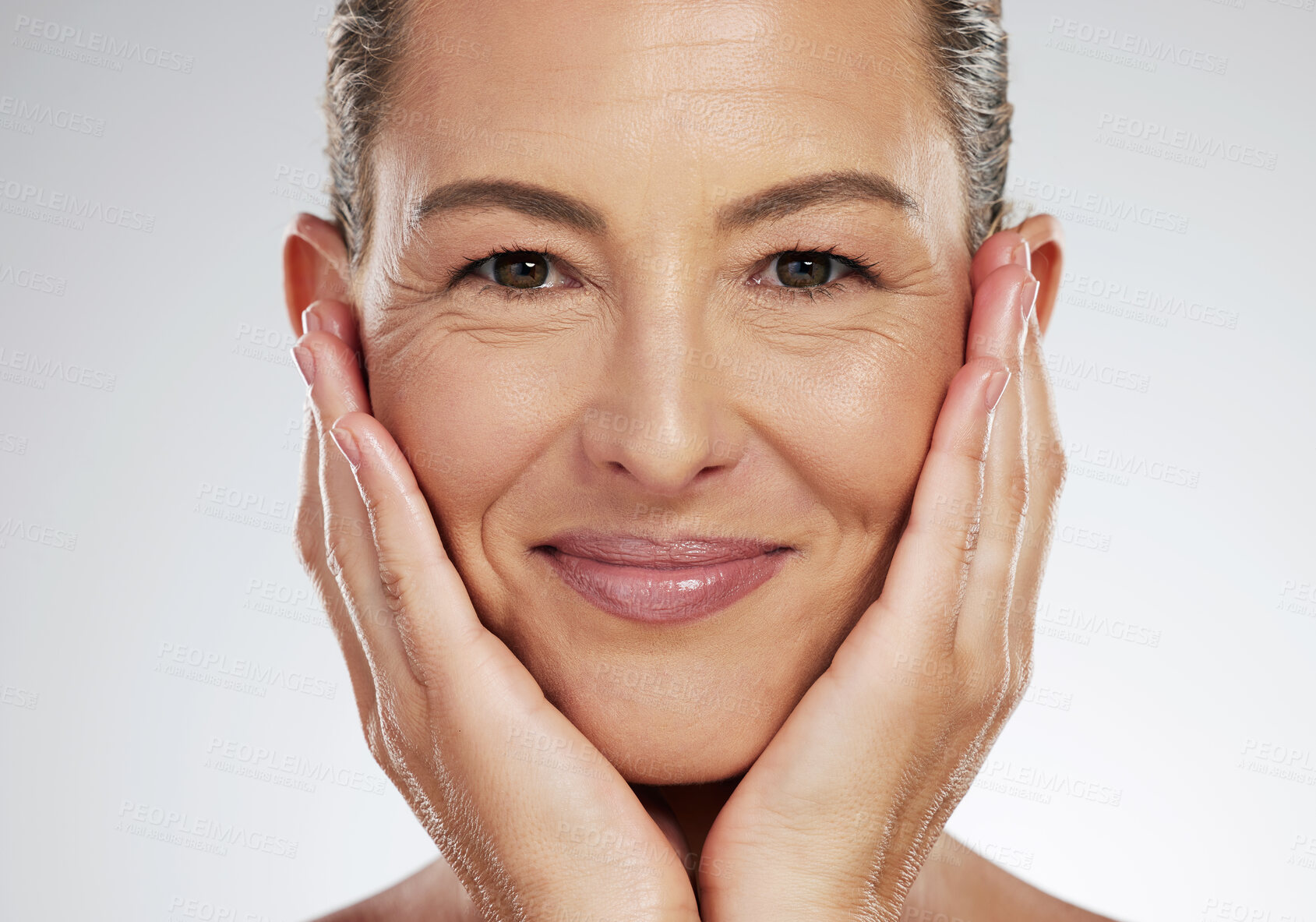 Buy stock photo Senior woman, face and skincare smile for beauty touching soft and smooth skin on a studio background. Closeup portrait of a isolated elderly female hands in beautiful facial care smiling for health