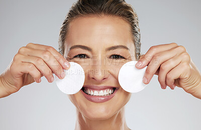 Buy stock photo Mature, model and skincare with pads by face in hands for cleaning in dermatology, beauty or facial portrait. Woman, smile and skin happy against studio backdrop for cosmetics, health and wellness