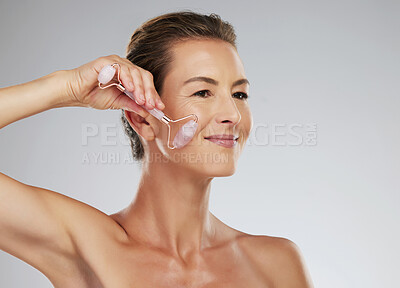 Buy stock photo Skincare, rose quartz and beauty of a senior woman busy with a cosmetic and facial treatment. Elderly person from Paris doing skin care, healthy, youth and anti aging wellness of a mature female 