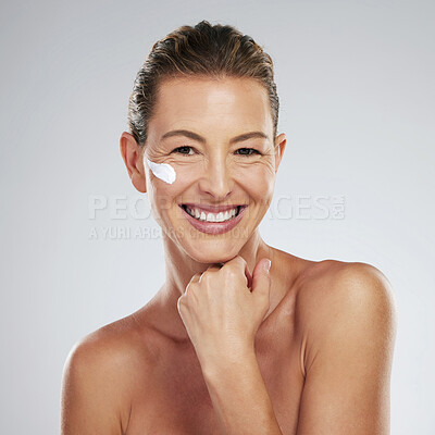 Buy stock photo Mature model, cream and skincare for face in beauty, wellness and happiness portrait in studio. Woman, skin and smile for anti-aging product for facial, cosmetic and health in portrait with grey wall