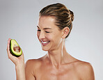 Woman, happy and avocado in hand for skin health, wellness and care show face in portrait. Mature model, dermatology and smile with fruit for skincare, hair and beauty with natural facial product