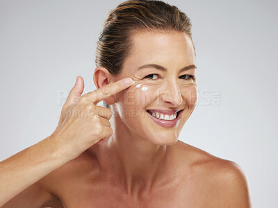 Buy stock photo Skincare, beauty and woman with face product for a morning facial healthcare and wellness routine in studio. Smile, relax and mature model happy to show her selfcare dermatology cosmetics and cream