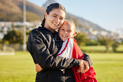 Buy stock photo Football coach, child and hug during sports training on outdoor field for soccer while showing support and motivation for match. Portrait of girl kid or junior player and her woman trainer in russia
