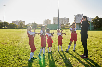 Buy stock photo Football girl team stretching with coach on a sports field for fitness, training and exercise. Soccer player club or athlete group and trainer teaching children or kids muscle wellness grass outdoor