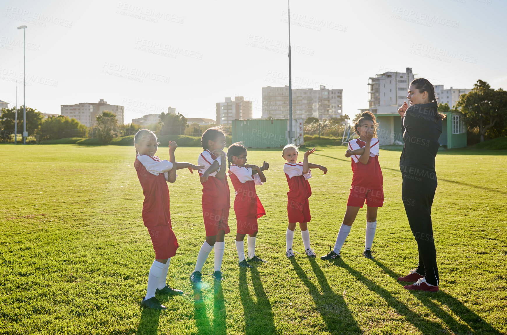 Buy stock photo Football girl team stretching with coach on a sports field for fitness, training and exercise. Soccer player club or athlete group and trainer teaching children or kids muscle wellness grass outdoor