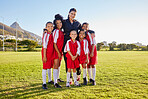 Team, soccer and coach smile on field together in portrait after training, game or workout in sun. Football, girl and woman with diversity in happy sports group on grass for teamwork in Cape Town