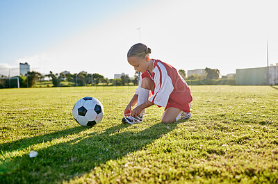 Buy stock photo Soccer, training and tie shoes with girl in sports workout for motivation, health and wellness. Exercise, growth and goals development with young child in football field for games, vision and fitness