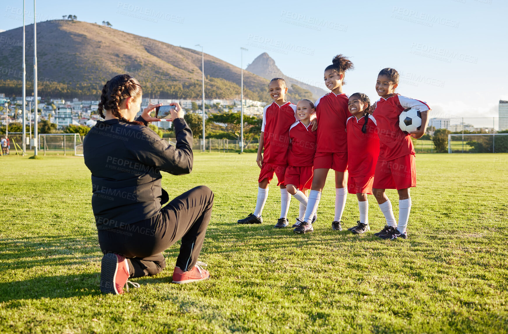 Buy stock photo Soccer, phone and team picture with coach, ball and sports girl group with a smile together on a field. Young female football squad happy with post for social media on a sports ground after training