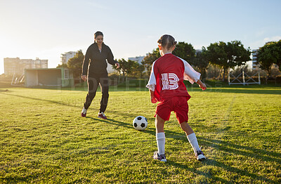 Soccer, coach mom and child sport on a outdoor school field with a ball for fitness and exercise. Mother training a kid student for football training, workout and children sports game kick together