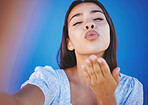 Blowing kiss, selfie and young woman on a summer vacation standing by a blue background. Lips, beauty and portrait of a beautiful girl from mexico taking a picture while on a holiday for social media