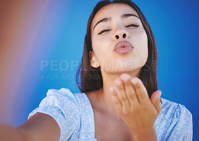 Buy stock photo Blowing kiss, selfie and young woman on a summer vacation standing by a blue background. Lips, beauty and portrait of a beautiful girl from Mexico taking a picture while on a holiday for social media