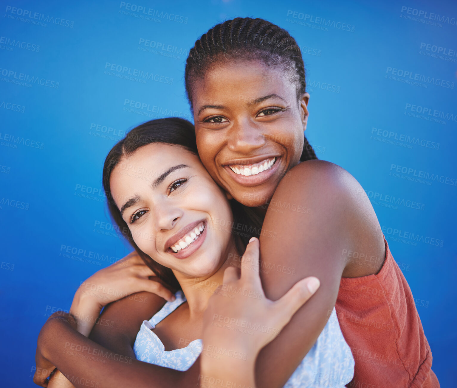 Buy stock photo Happy, friends and portrait of women hugging for support, empowerment and love in studio. Happiness, smile and interracial girls with friendship embracing with care while standing by blue background.