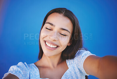 Buy stock photo Happy woman with natural beauty, selfie for social media and with a smile on her face on blue background. Portrait of a pretty young girl, wellness and photo of glowing healthy skin on summer holiday