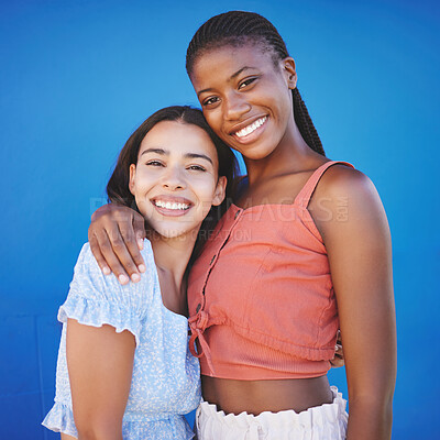 Buy stock photo Black women, friends and hug with happy smile on a blue studio background. Portrait, diversity and lesbian couple in love embrace, care and support posing, bonding and spending quality time together.