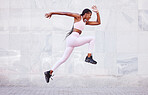 Energy, sports and black woman jump running outdoor for fitness, wellness and outdoor training with wall mockup. Young, healthy african girl in athlete runner clothes for fashion mock up background