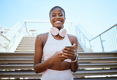 Buy stock photo Fitness, music and phone with black woman by stairs for streaming service or social media while exercise, workout or training. Mobile, wellness and portrait of girl with headphones for sports