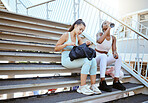 Fitness, friends relax and break on stairs after running workout together and drinking water in the outdoors. Athletic women relaxing on a stairway in exercise training for health and wellness