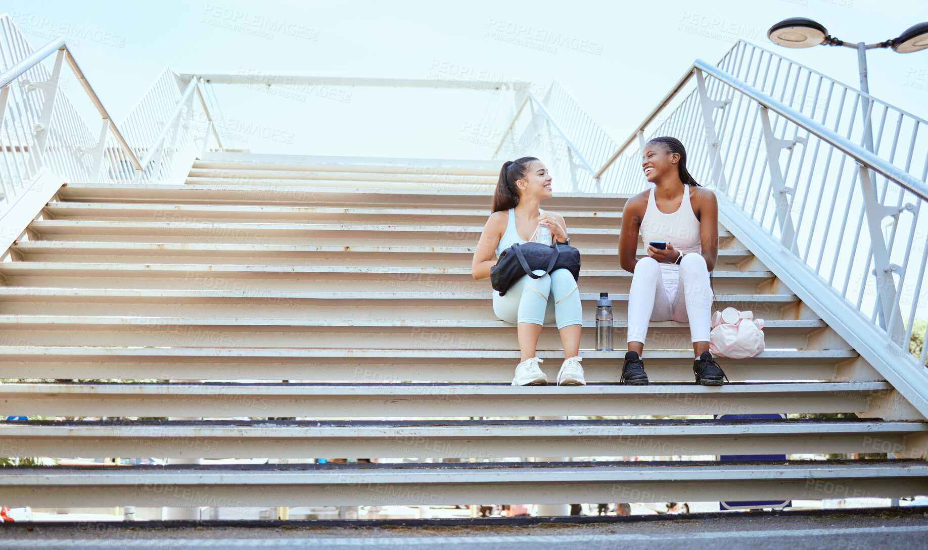 Buy stock photo Friends, happy and relax after exercise on steps together, talking and bonding after morning cardio outdoors. Smiling, cheerful and females resting on stairs, enjoying free time after workout in city