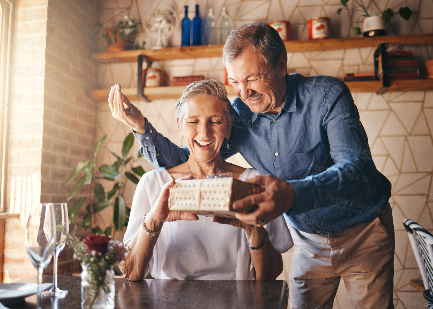 Buy stock photo Love, couple elderly and gift to celebrate anniversary on date with smile, happy and excited together. Romance, mature man and older woman exchange present relax, being loving and bonding at home.