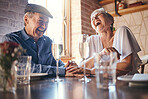 Love, laughing and old couple holding hands at a restaurant on a romantic wine date in celebration of a happy marriage. Smile, relaxed and senior woman enjoying glass of champagne with funny partner