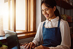 Coffee shop owner on laptop, startup and woman from Singapore typing email or planning menu online. Happy manager at cafe or restaurant reading review on shop social media or positive sales report.