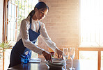 Restaurant waitress cleaning dishes from table after a  meal. Customer service, diner and working in the food industry as a waiter clearing dirty plates, glasses and leftovers to clean dinner table
