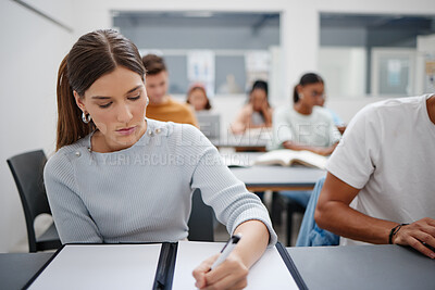 Buy stock photo Woman, student and writing university exam in classroom for higher education, scholarship and training. Focused female learning and taking notes in workshop with group of college students
