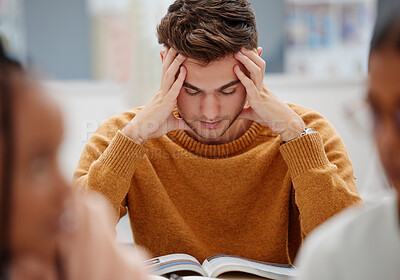 Buy stock photo Study, stress and student at university with anxiety for a test. Young man with headache, worried and studying with textbook on desk in library. Tired in education, learning and stressed about exam