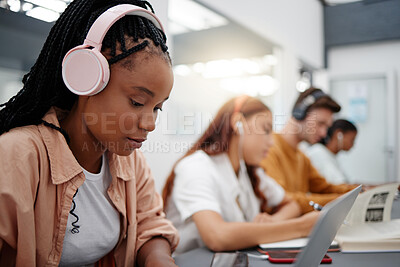 Buy stock photo Education, headphones and black woman in university on laptop, typing notes and studying for test. Learning, college and female listening to music, educational podcast or radio working on project.
