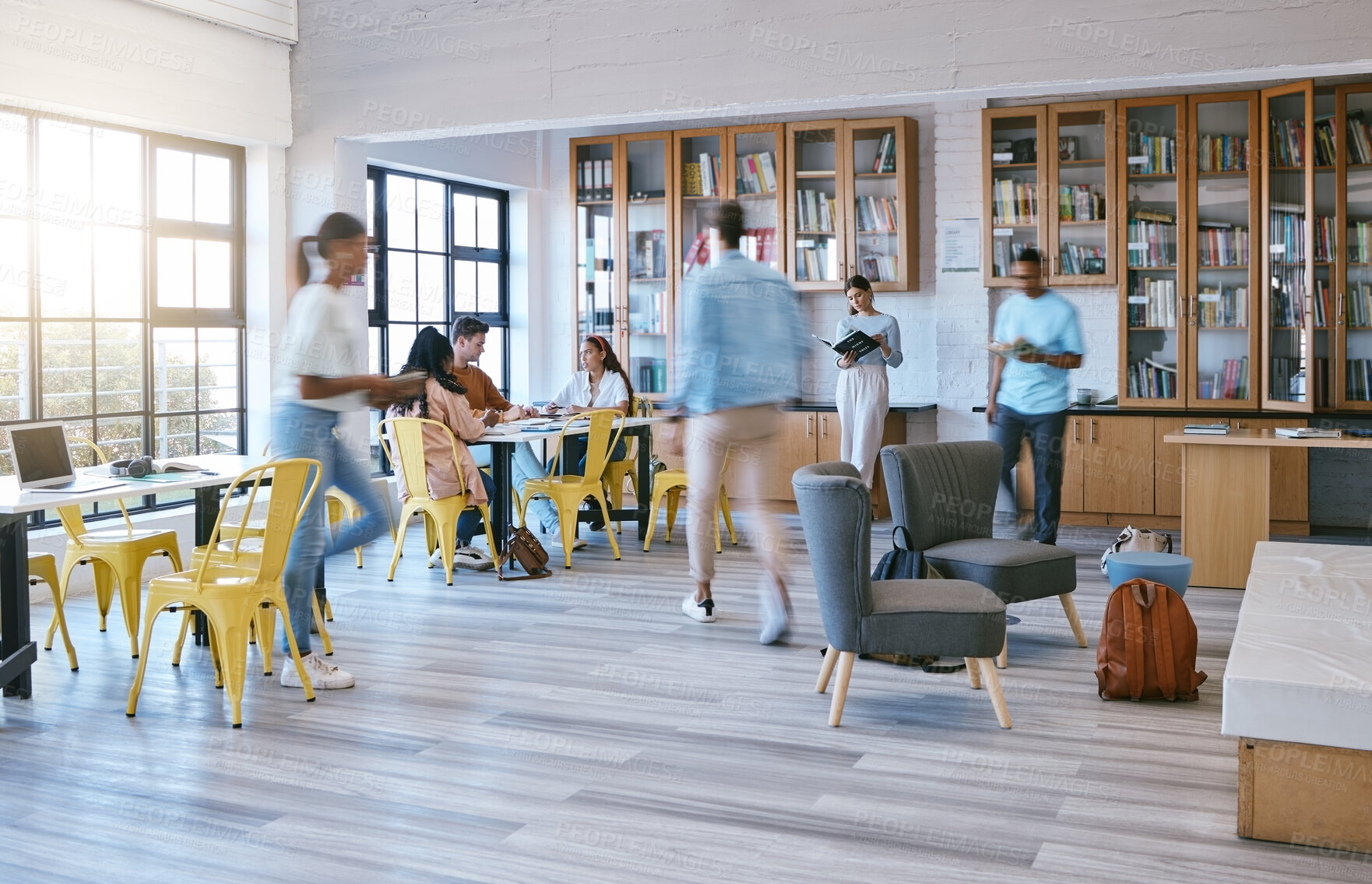 Buy stock photo Creative campus, busy library and students studying, research or working in community workspace with morning lens flare. People with education school books, reading information in college motion blur