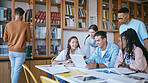 Collaboration, education or laptop with students in library for data research, innovation or diversity for university project. Computer, teamwork or creative strategy planning in classroom of college