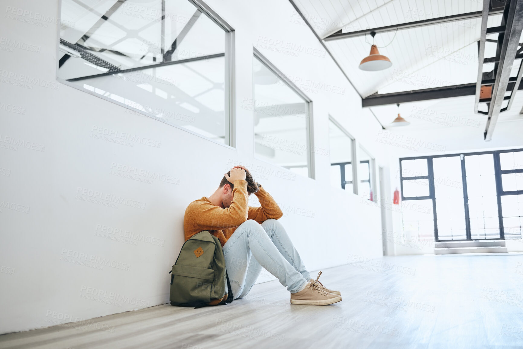Buy stock photo Young man, mental health and stress student, depressed and on floor holding head in empty room. Burnout, male and frustrated with fear, social anxiety and anxious with tired, overworked and scared.