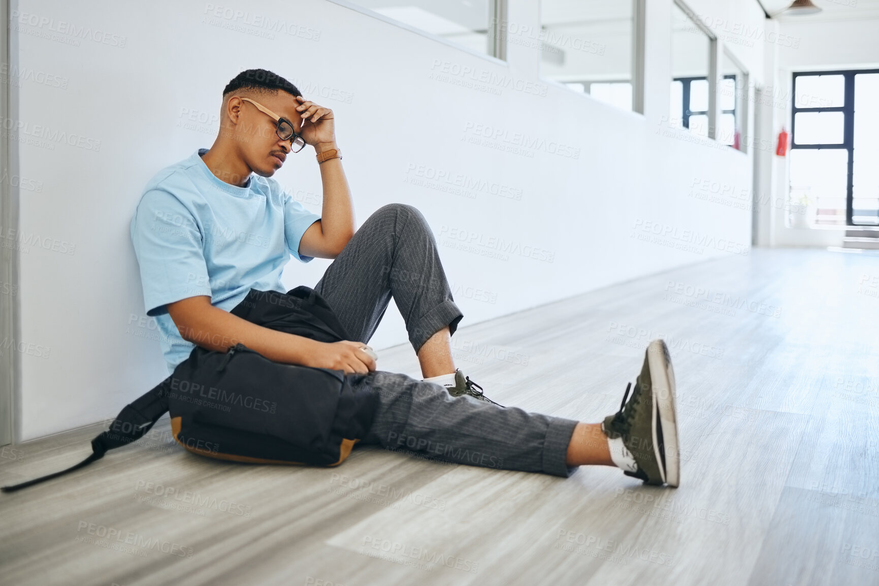 Buy stock photo Depression, mental health and student thinking on a floor, stress and social anxiety at university. Fear, debt and bully risk by black man hiding in an empty lobby, looking hopeless and overwhelmed