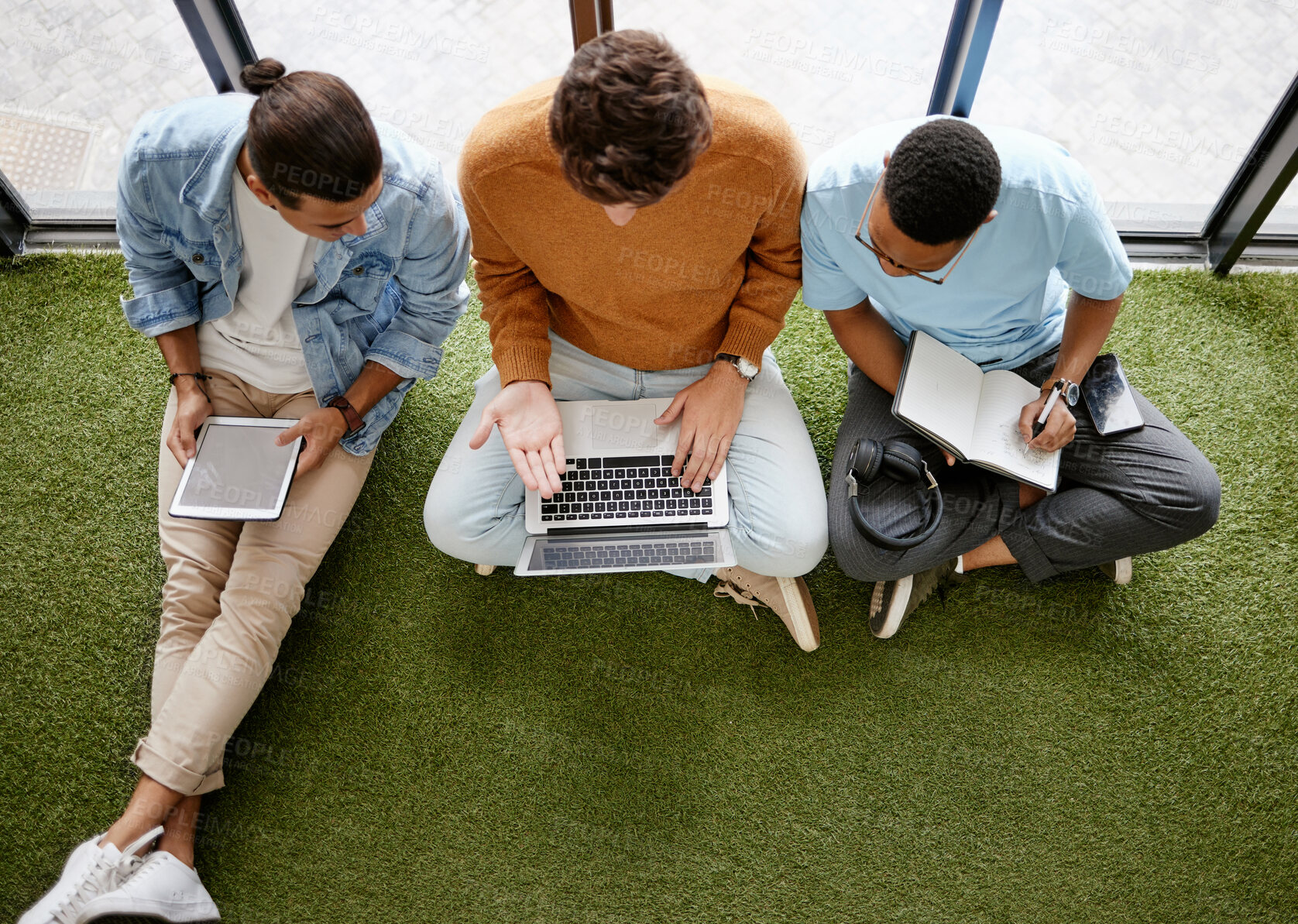 Buy stock photo Notebook, tablet and laptop business men in a creative startup office brainstorming idea online. Planning, strategy and digital marketing in workplace. Team talking on floor in workspace from above