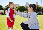 Girl, coach and soccer for motivation, inspiration and help on field for better performance in sport. Woman, child and football together on grass talking for advice, learning and guidance in game