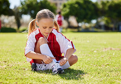 Buy stock photo Sports, girl and soccer player with child on grass before outdoor game and exercise. Kids, fitness and shoes during football training, getting ready for exercise and soccer practice on a field