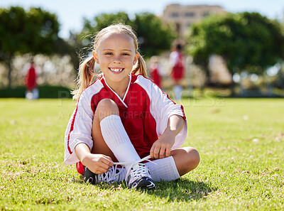 Buy stock photo Soccer player, fitness and girl on field, soccer training and sports activity outdoor. Sport, health and exercise with child relax on grass, prepare for football game, checking shoes, happy and smile