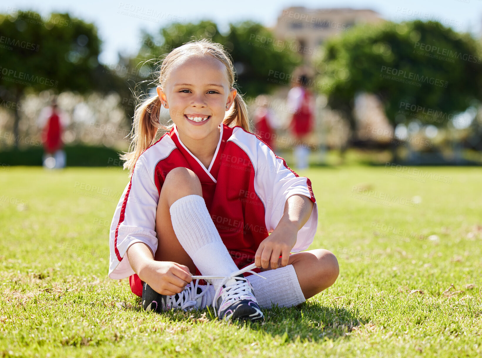 Buy stock photo Soccer player, fitness and girl on field, soccer training and sports activity outdoor. Sport, health and exercise with child relax on grass, prepare for football game, checking shoes, happy and smile